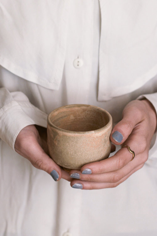 Kobieta trzymająca w rękach japońską czarkę na herbatę